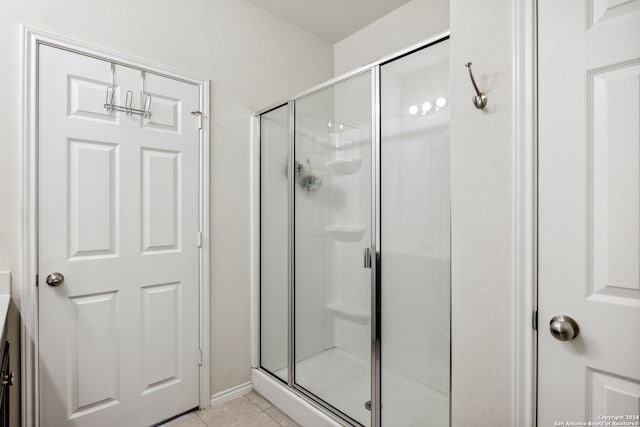 bathroom with tile patterned floors and a shower with shower door