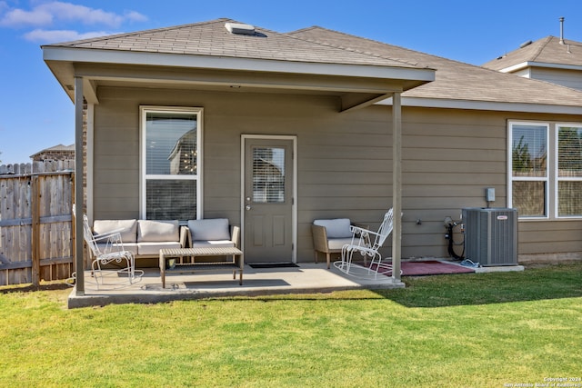 rear view of house featuring central air condition unit, a patio, and a lawn