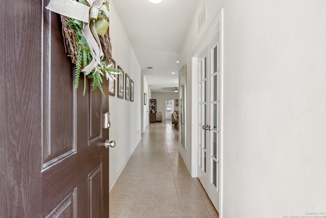 corridor with french doors and light tile patterned flooring