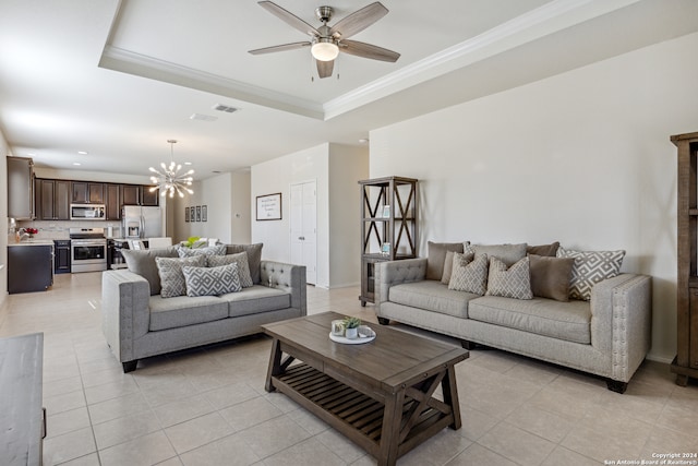 living room featuring a raised ceiling, ornamental molding, light tile patterned flooring, and ceiling fan with notable chandelier