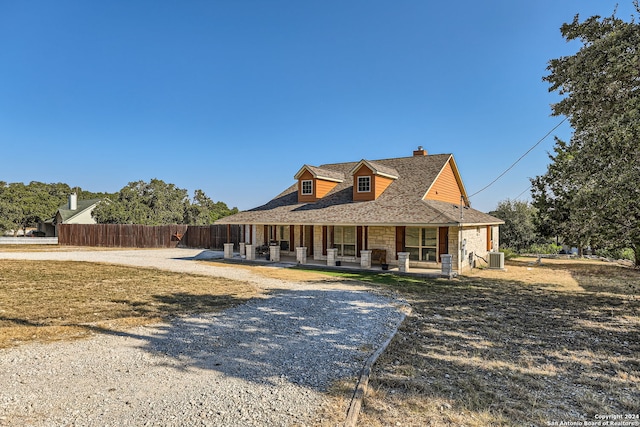 farmhouse inspired home featuring a porch and central air condition unit