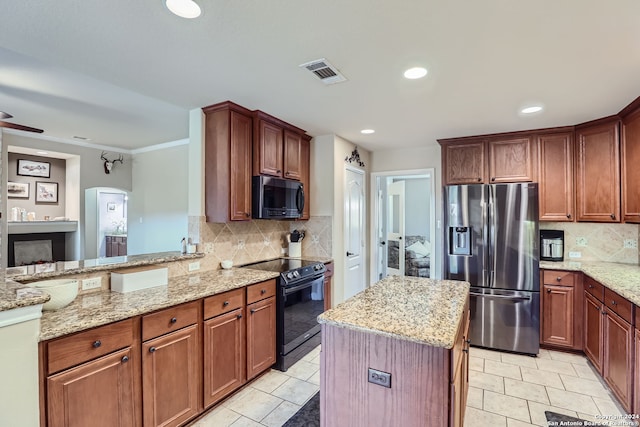 kitchen featuring light stone countertops, appliances with stainless steel finishes, and tasteful backsplash