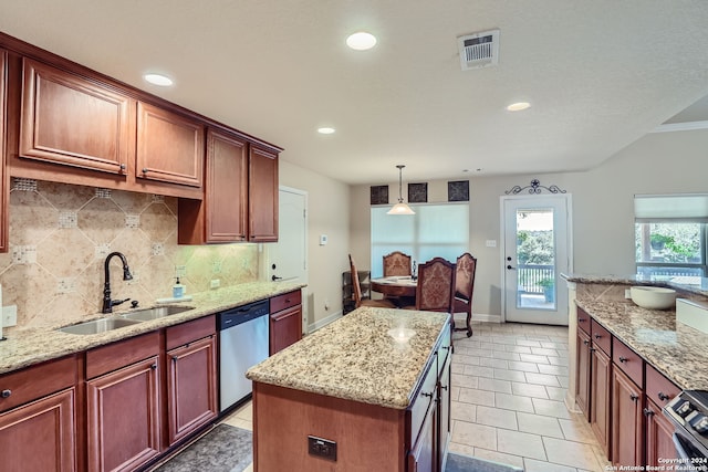 kitchen featuring light stone countertops, appliances with stainless steel finishes, sink, a center island, and hanging light fixtures