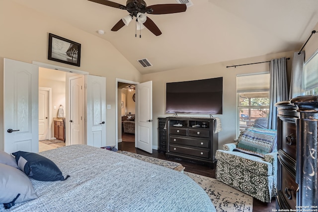 bedroom featuring dark hardwood / wood-style flooring, lofted ceiling, ensuite bath, and ceiling fan