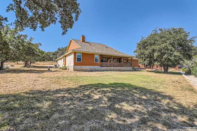 back of property featuring a yard and a porch