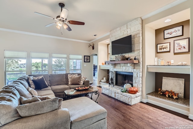 living room featuring ceiling fan, ornamental molding, a fireplace, and hardwood / wood-style floors