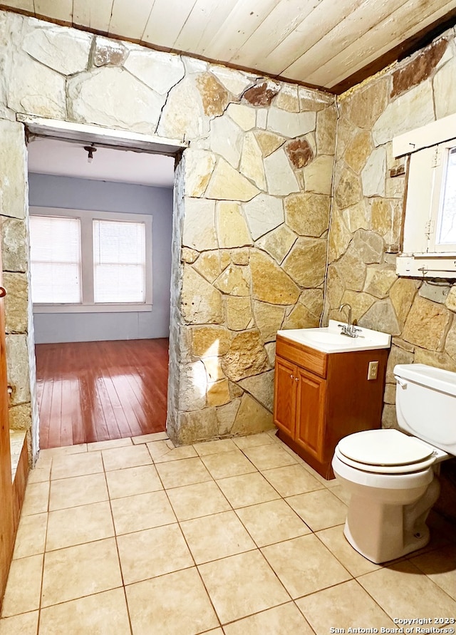 bathroom featuring vanity, toilet, hardwood / wood-style flooring, and wooden ceiling