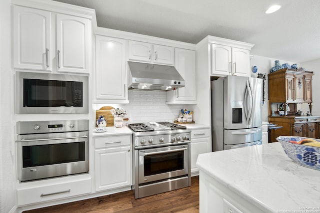 kitchen with tasteful backsplash, appliances with stainless steel finishes, dark hardwood / wood-style flooring, and white cabinets