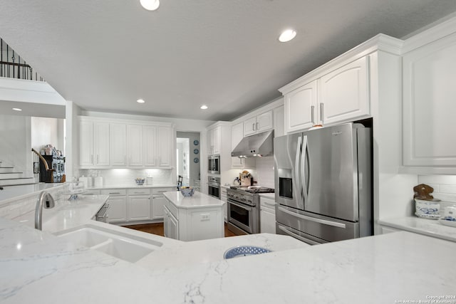 kitchen with appliances with stainless steel finishes, white cabinets, and tasteful backsplash