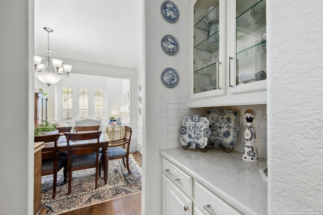 dining space featuring a notable chandelier, ornamental molding, and dark hardwood / wood-style flooring