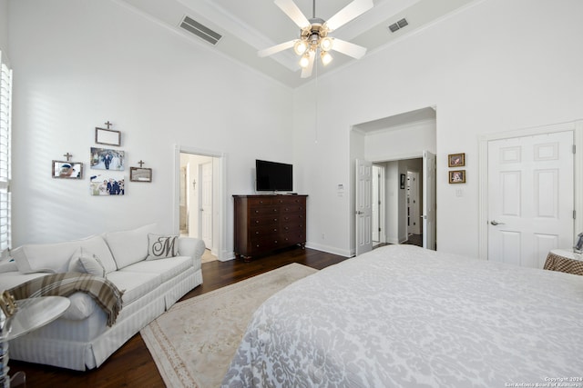 bedroom with a high ceiling, ornamental molding, ceiling fan, ensuite bathroom, and dark hardwood / wood-style flooring