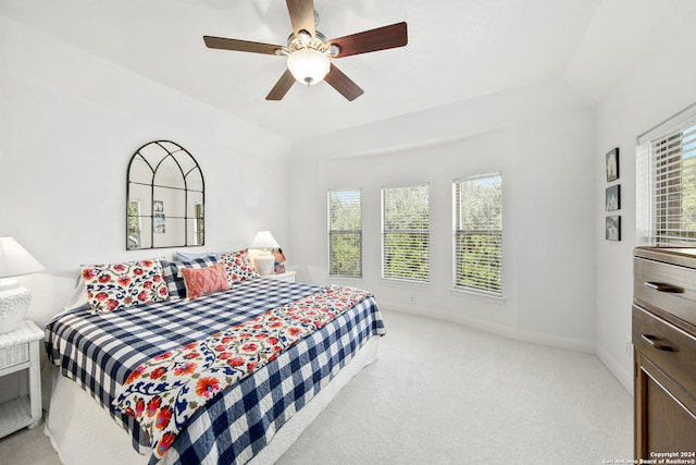 bedroom featuring vaulted ceiling, light carpet, and ceiling fan