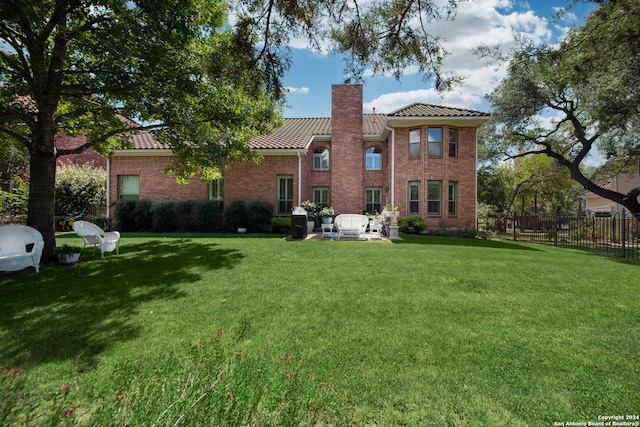 back of house featuring a patio and a lawn