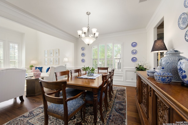 dining area with an inviting chandelier, crown molding, and dark hardwood / wood-style flooring