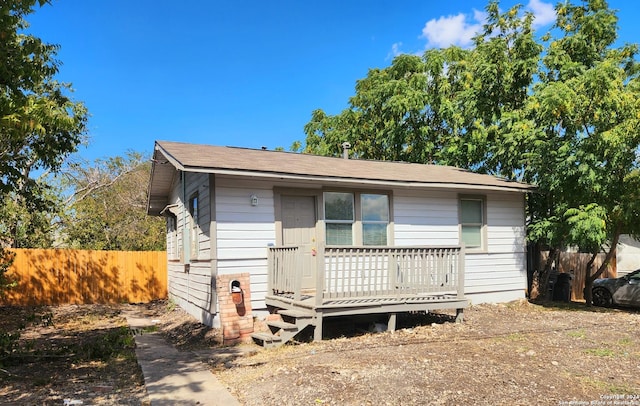 view of front facade with a deck and fence