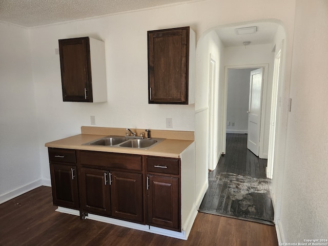 kitchen with dark wood-type flooring, dark brown cabinets, and sink