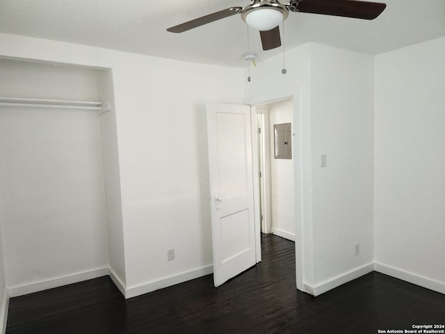 unfurnished bedroom featuring a closet, ceiling fan, electric panel, and dark hardwood / wood-style floors