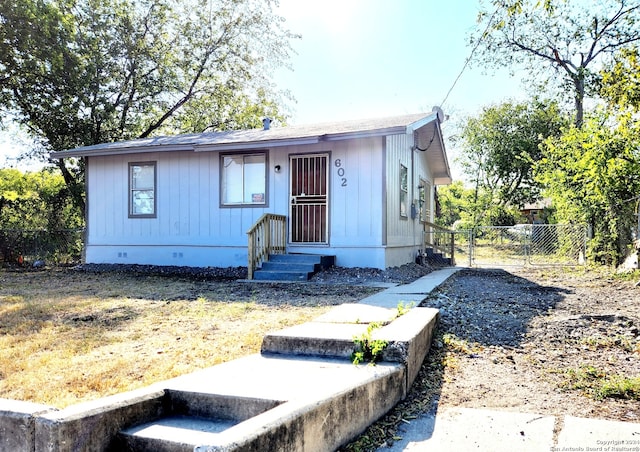 view of front facade with fence and crawl space
