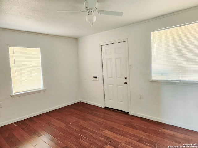 unfurnished room with ceiling fan, baseboards, and dark wood-type flooring