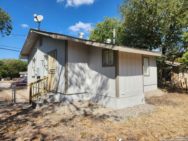 view of side of home featuring fence and entry steps