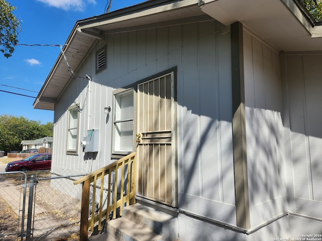 view of side of home with fence and entry steps