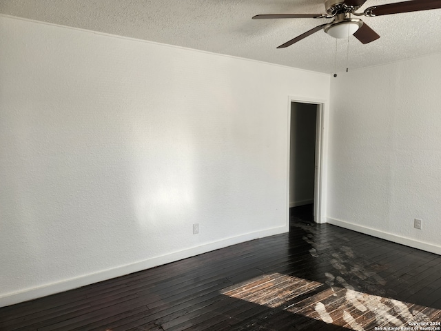 spare room with a textured ceiling, ceiling fan, and dark hardwood / wood-style flooring