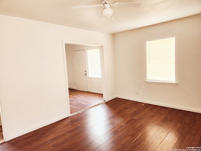 empty room featuring hardwood / wood-style floors, baseboards, and ceiling fan
