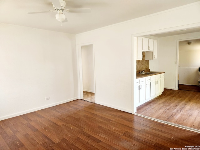 unfurnished living room with baseboards, wood finished floors, and a ceiling fan
