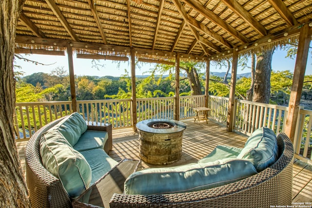 wooden terrace with a gazebo and an outdoor living space with a fire pit