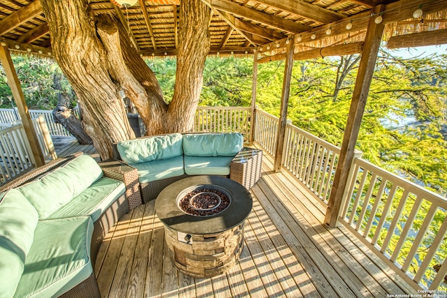 deck with an outdoor living space with a fire pit