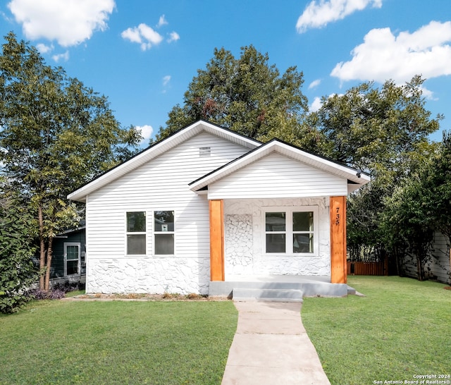 view of front of house with covered porch and a front lawn