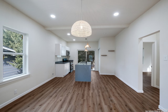 kitchen with stainless steel appliances, sink, pendant lighting, white cabinets, and dark hardwood / wood-style flooring