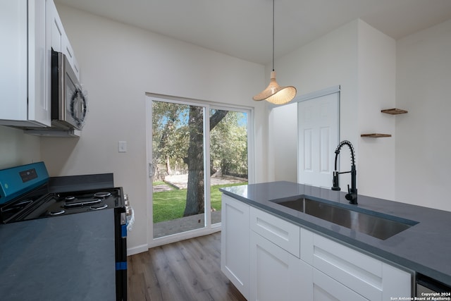 kitchen featuring white cabinetry, light hardwood / wood-style floors, electric range, and sink