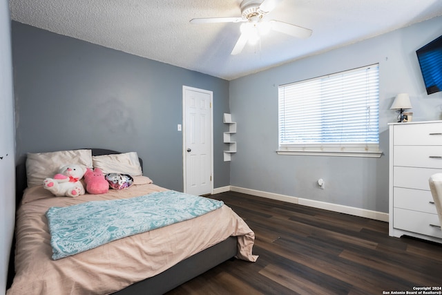 bedroom featuring dark wood-type flooring, a textured ceiling, and ceiling fan