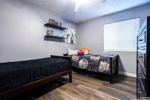 bedroom with hardwood / wood-style floors and ceiling fan