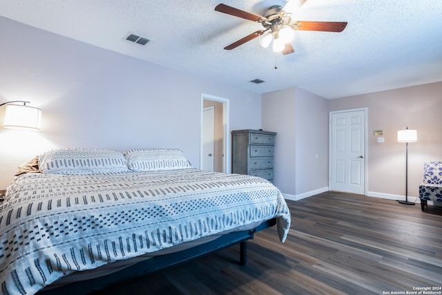 bedroom with a textured ceiling, dark wood-type flooring, and ceiling fan