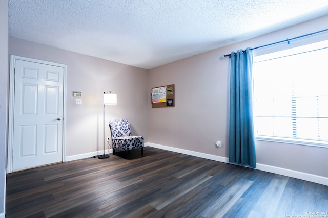 unfurnished room with a textured ceiling and dark hardwood / wood-style floors