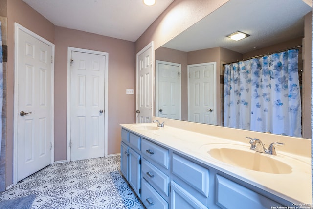 bathroom featuring vanity, a textured ceiling, and curtained shower