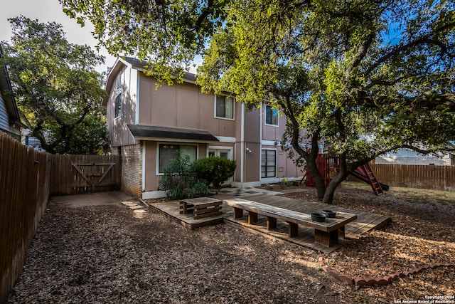 rear view of house featuring a playground