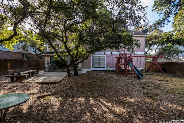 view of yard featuring a wooden deck and a playground