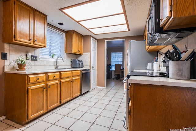 kitchen featuring light tile patterned floors, stainless steel appliances, sink, and backsplash