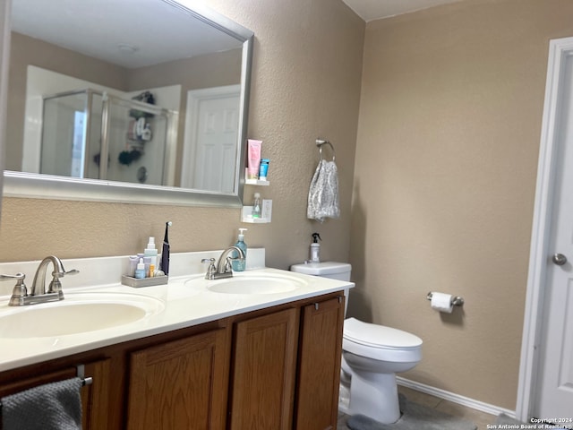 bathroom with vanity, tile patterned floors, toilet, and walk in shower