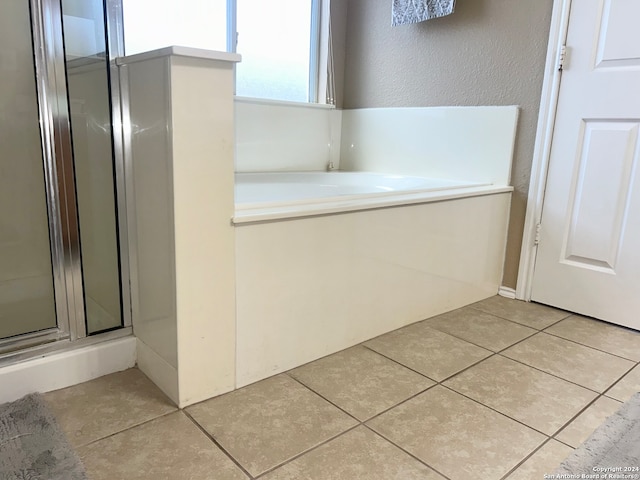 bathroom with walk in shower and tile patterned flooring