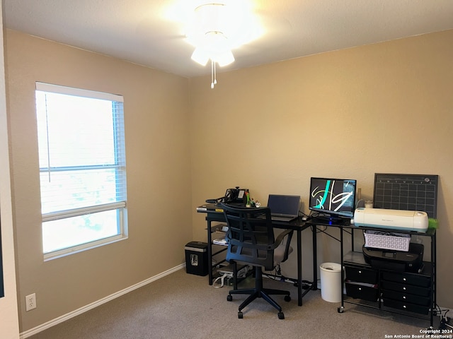 carpeted office space featuring ceiling fan