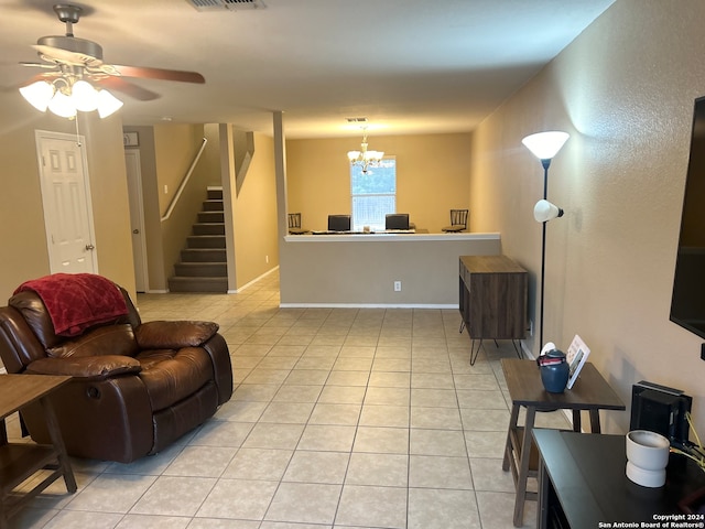 tiled living room with ceiling fan with notable chandelier