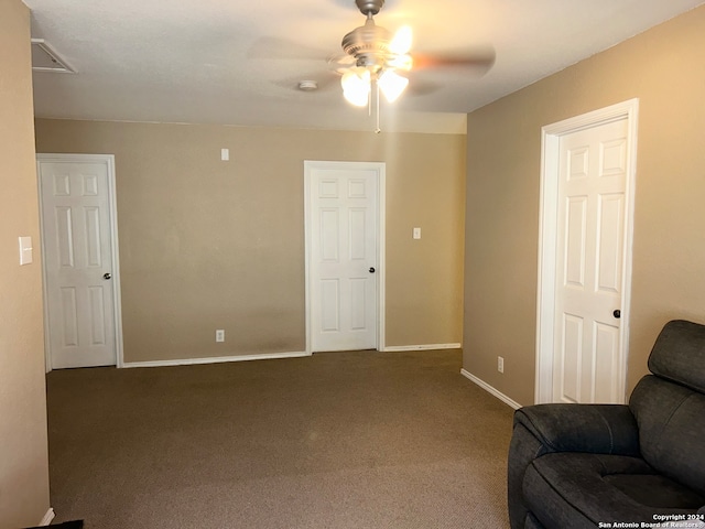 living area featuring ceiling fan and dark carpet