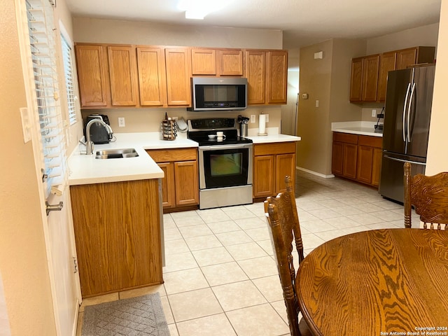 kitchen featuring appliances with stainless steel finishes, sink, and light tile patterned floors