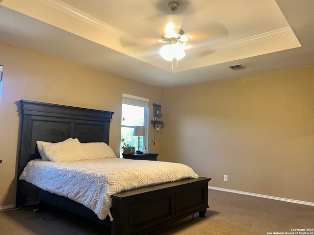 bedroom featuring ornamental molding, a raised ceiling, carpet flooring, and ceiling fan