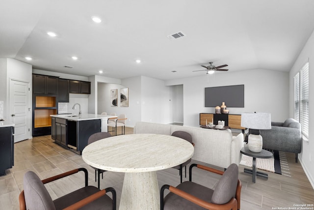 dining room featuring ceiling fan, lofted ceiling, and sink