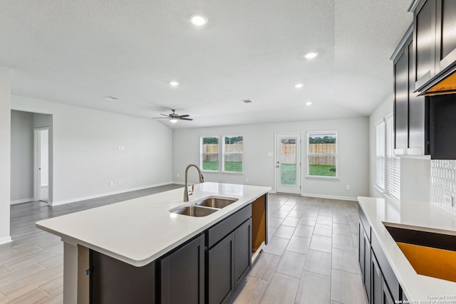 kitchen with an island with sink, sink, and ceiling fan